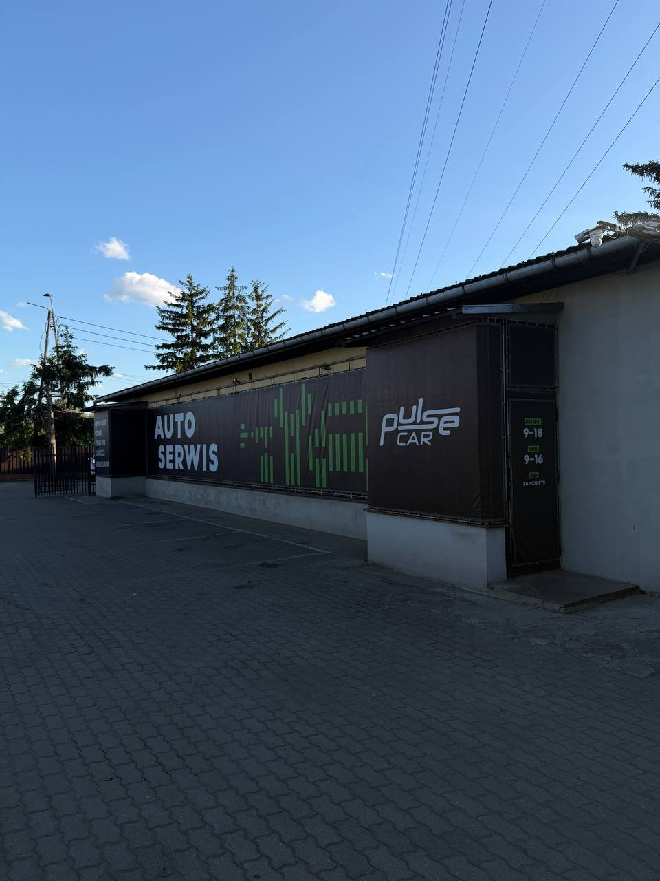 Fasada serwisu PulseCar z logo i godzinami otwarcia